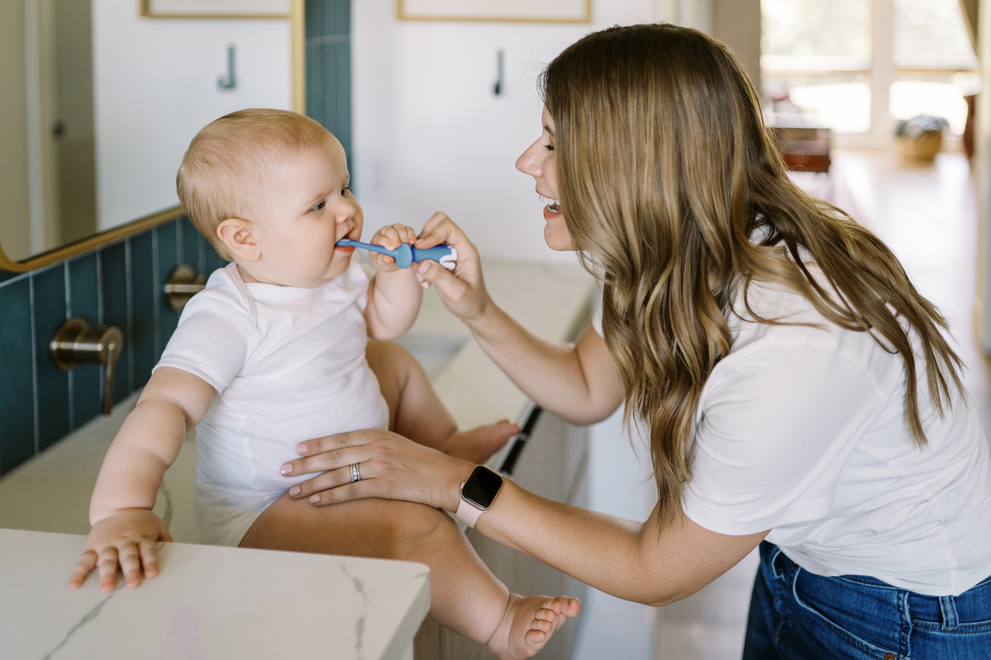 Mamá cepillando suavemente las encías de su bebé con cepillo Dr. Brown's Infant-to-Toddler