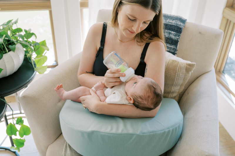 Mamá con posición segura dando mamadera Dr. Brown's al bebé