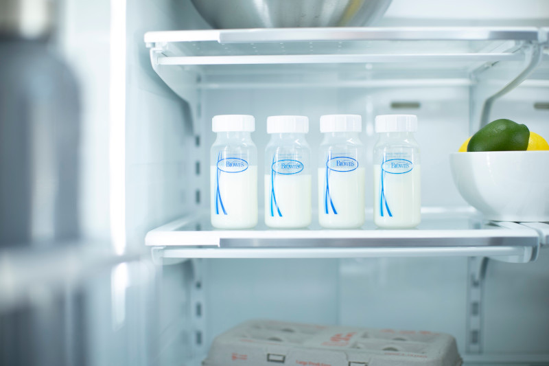 Bolsas de almacenamiento y mamaderas con leche materna organizada en el refrigerador