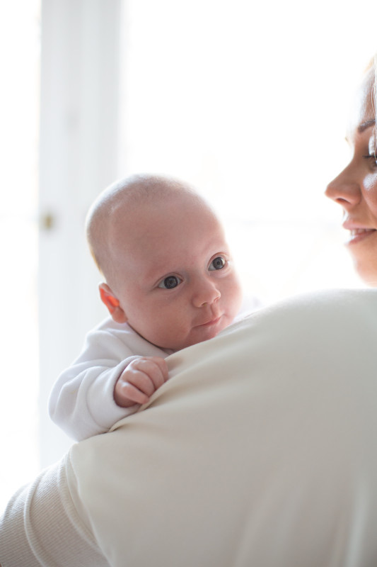 Padre sosteniendo a su bebé recién nacido mientras observa señales de salud
