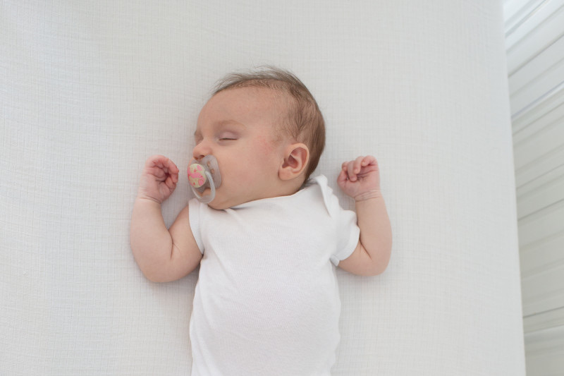 Bebé durmiendo tranquilo con chupete Dr. Brown's Advantage en cuna segura