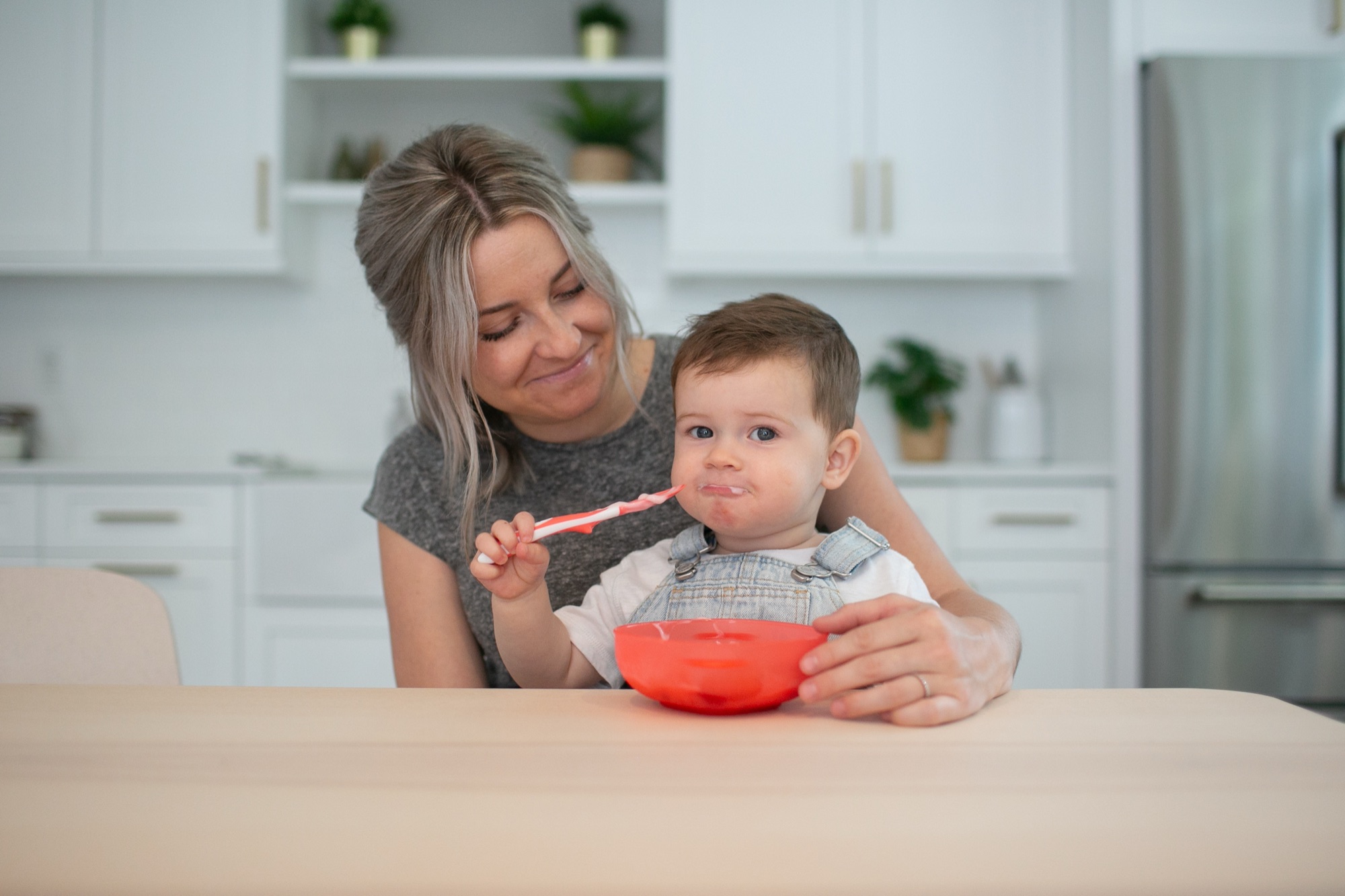 Mamá alimentando a su bebé con cuchara blanda en su primera introducción de sólidos