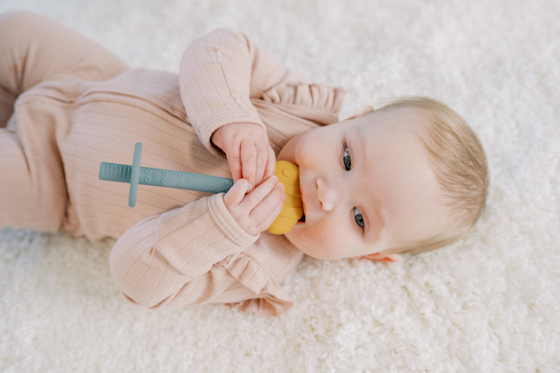 Mordedor snail de Dr. Brown's colocado en el suelo frente al bebé para motivar el tummy time
