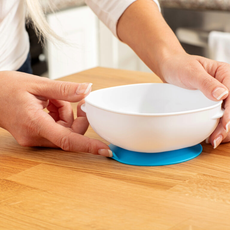 Manos fijando al mesón un bowl con ventosa de Dr. Brown's