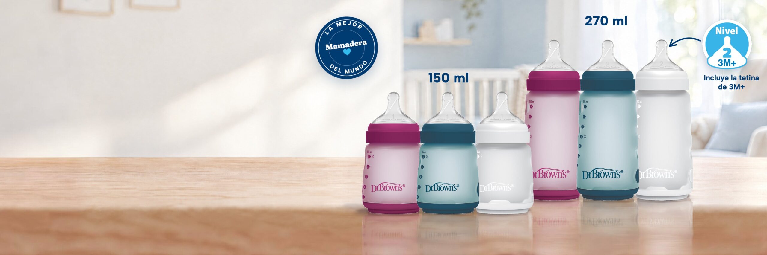 Mamaderas de silicona boca ancha Dr. Brown's de 150 y 270 ml en rosado, azul y marfil sobre una mesa, con el sello «La mejor mamadera del mundo» y la tetina Nivel 2 de 3M+ incluida en la de 270 ml